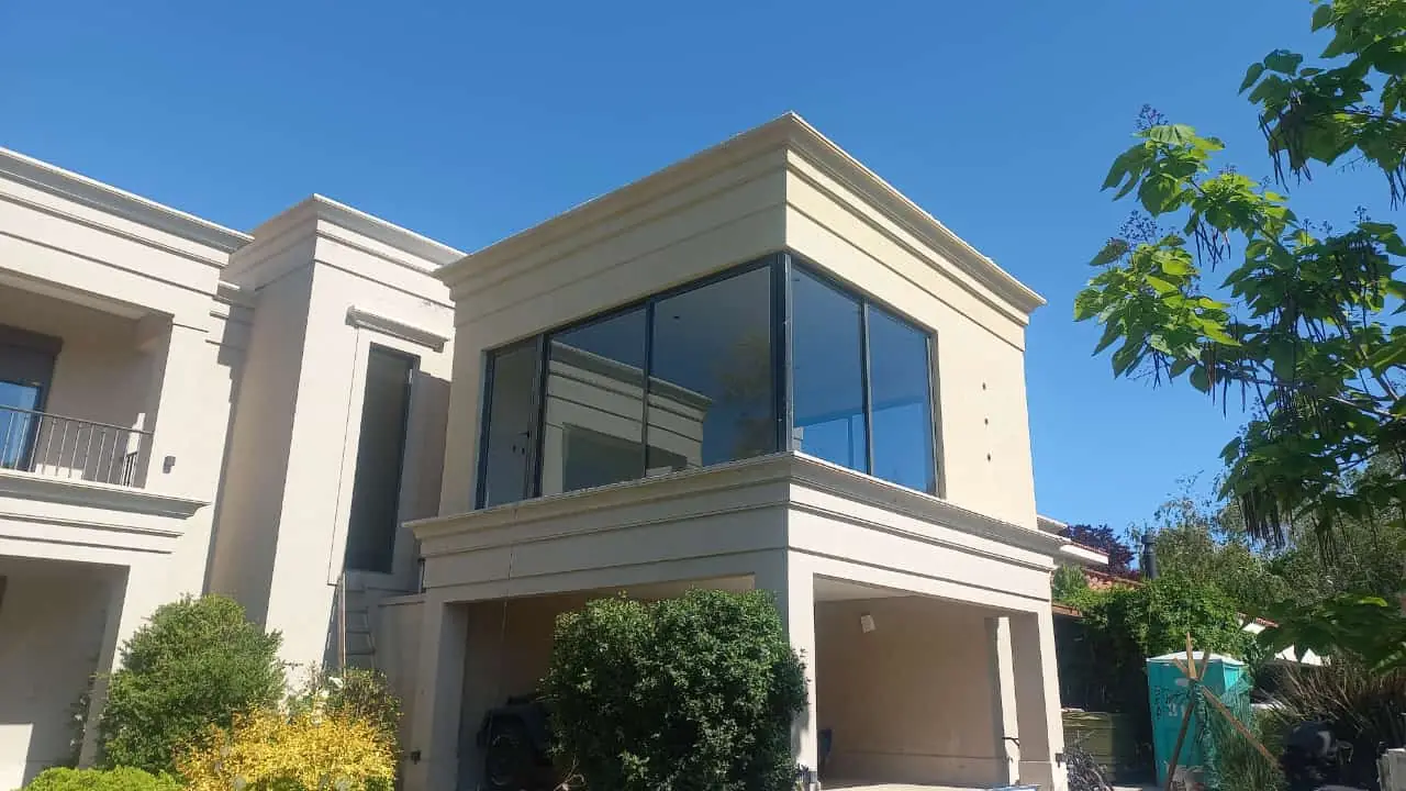 Ampliación terminada con ventanal en esquina sobre la vivienda existente