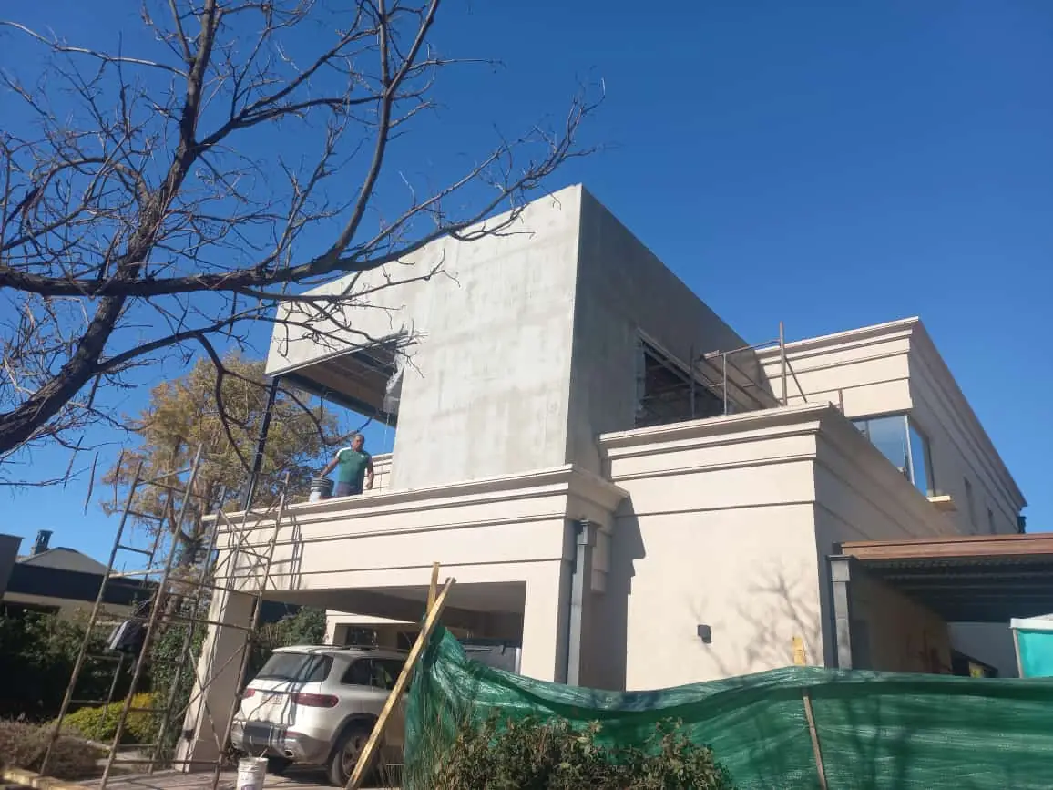 Volumen superior revocado en gris visto desde el jardín delantero