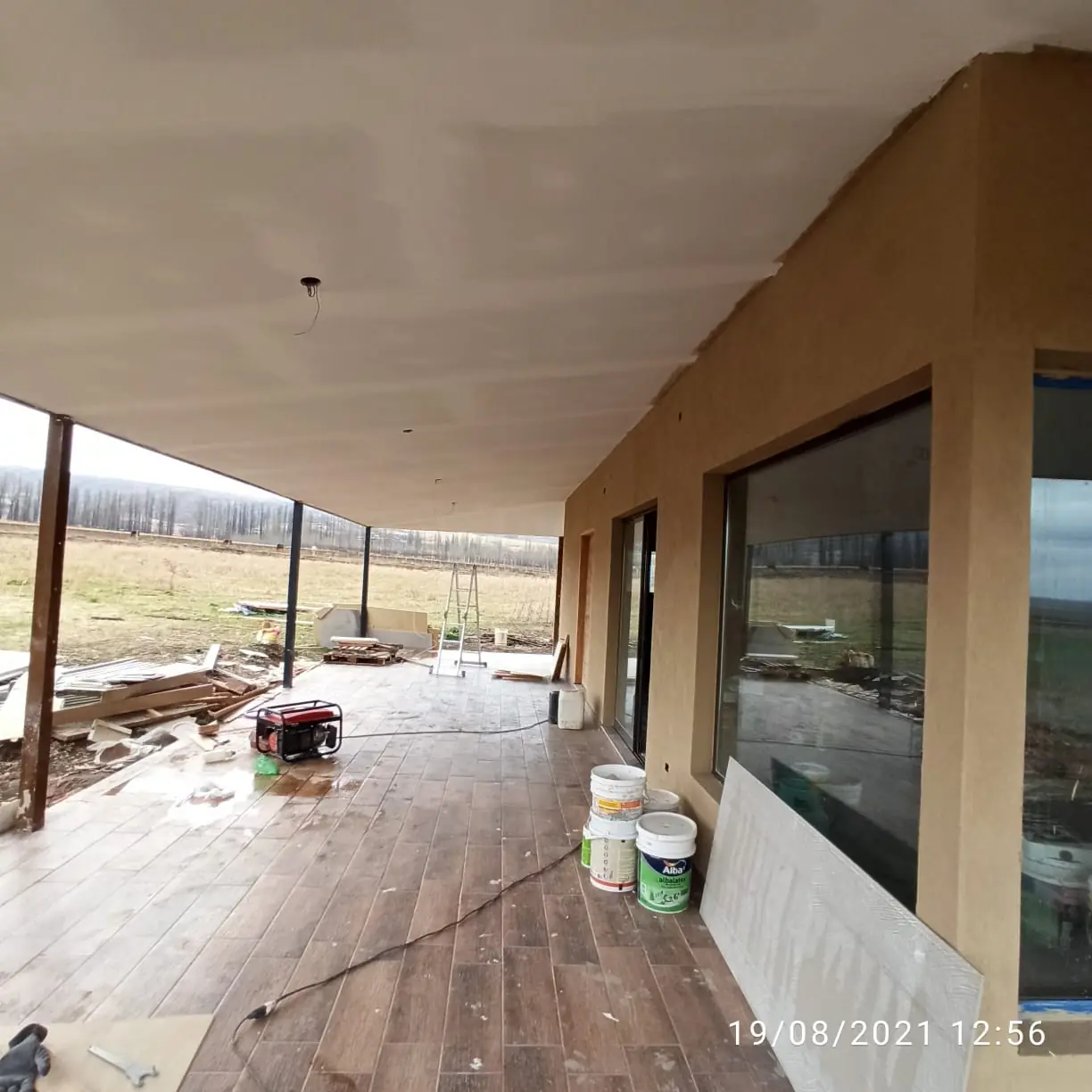 Estar en obra con ventanales corridos hacia la arboleda y el terreno