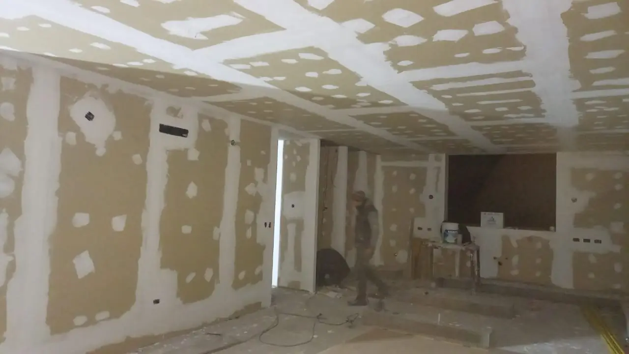 Ambiente interior terminado con cielorraso y paredes revocadas listas para pintar