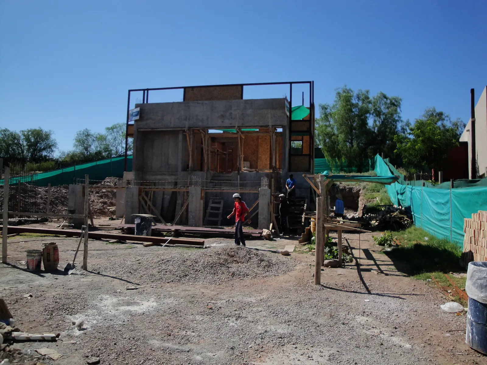 Obra en avance con la planta alta montada y personal trabajando