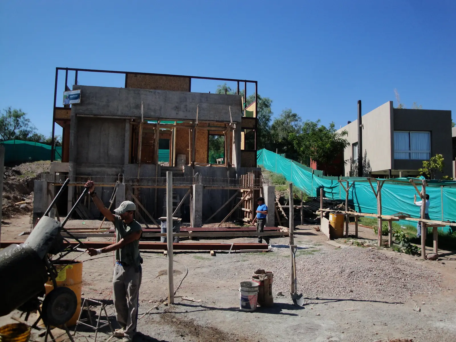 Preparación de hormigón en obra frente a la estructura de dos plantas