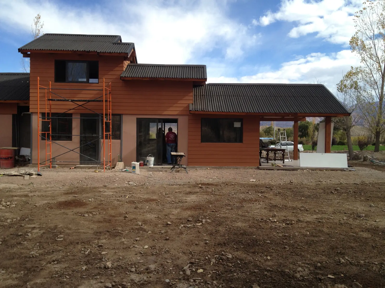 La casa casi terminada con revestimiento de madera y cubierta metálica oscura