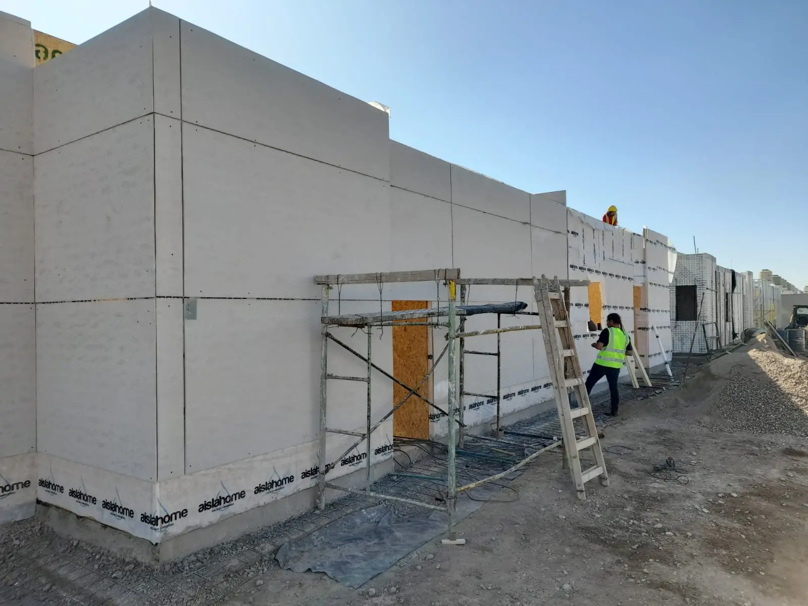 Volumen de doble altura en paneles SIP con andamio y operario trabajando