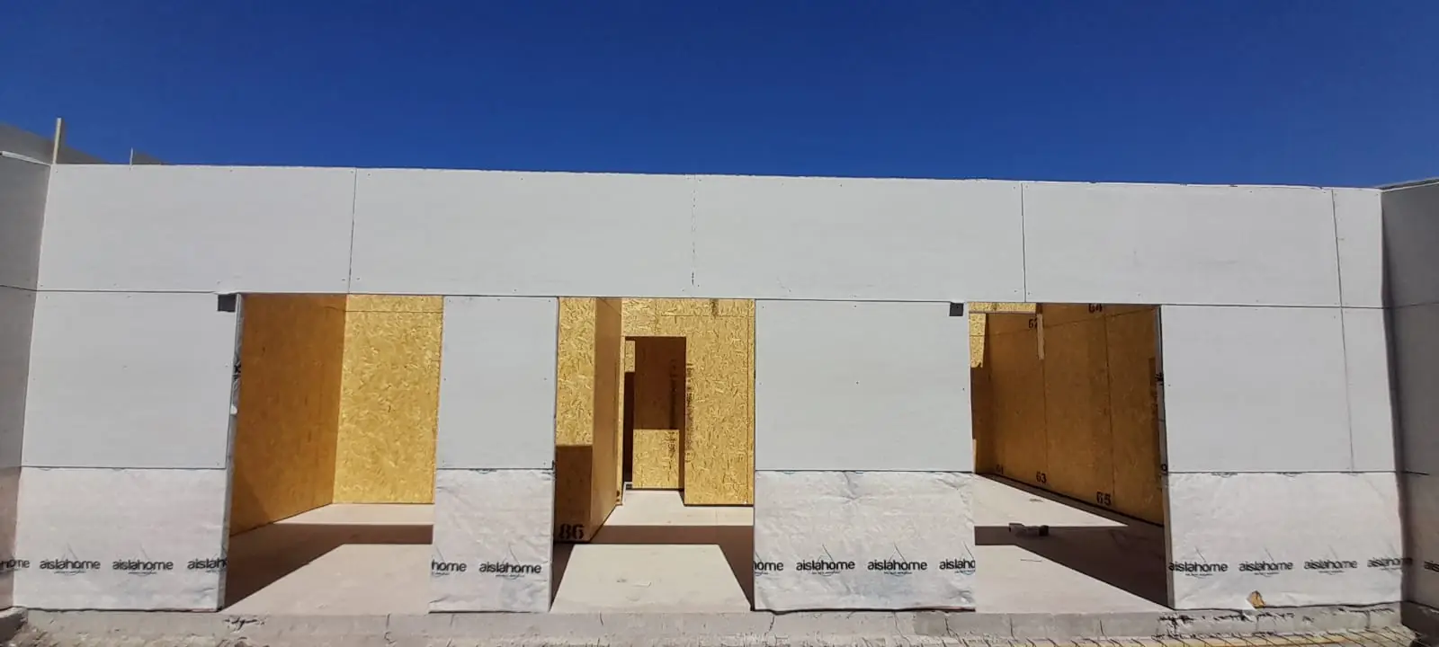 Frente de vivienda con vanos de puerta y ventana cerrados con placas