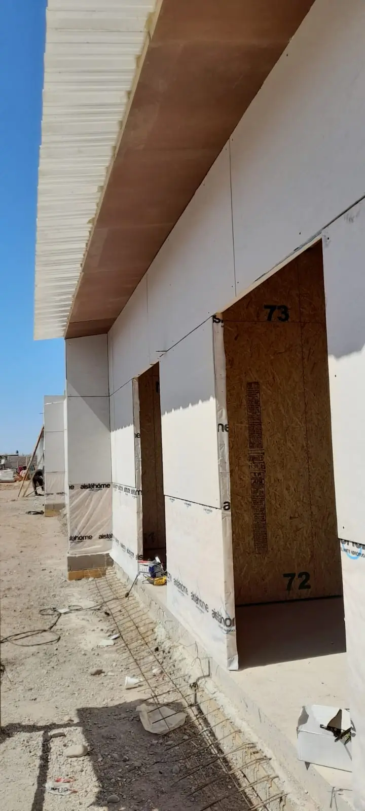Vista lateral bajo el alero con tres vanos de puerta numerados