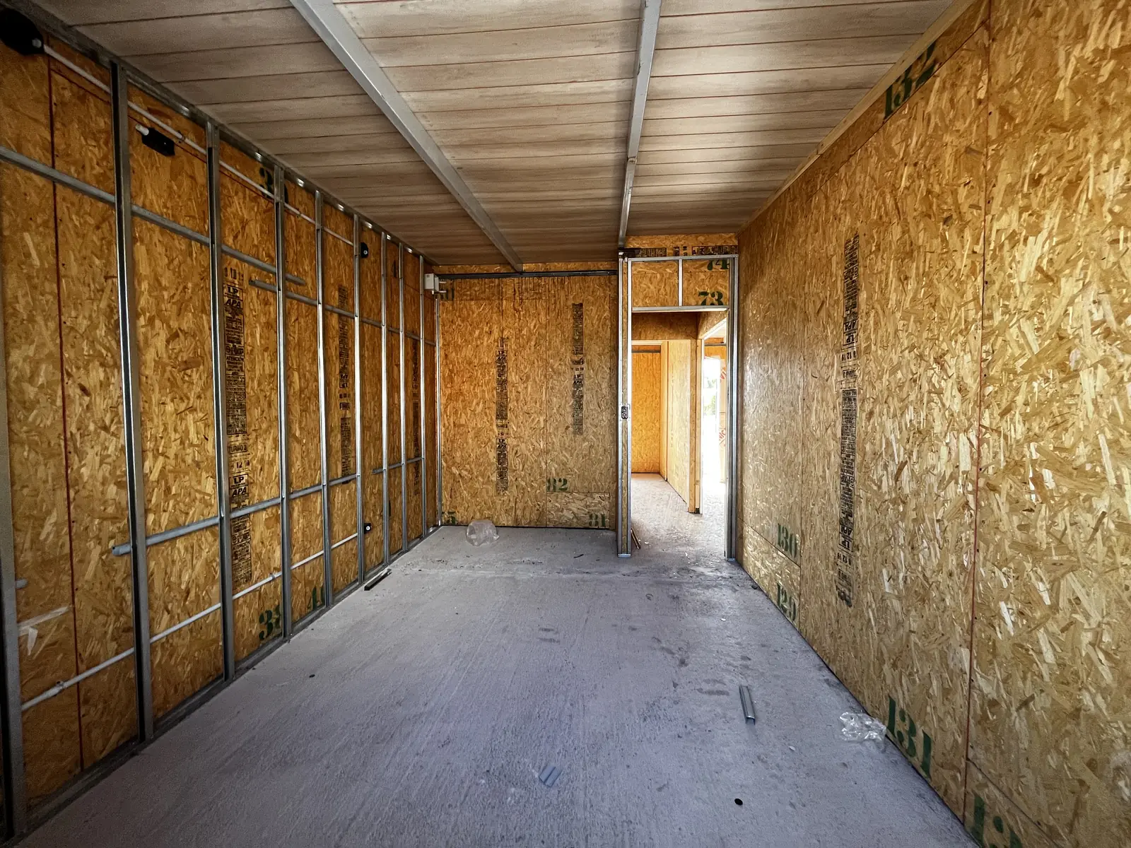 Pasillo interior con tabiques de panel SIP y cielorraso de chapa