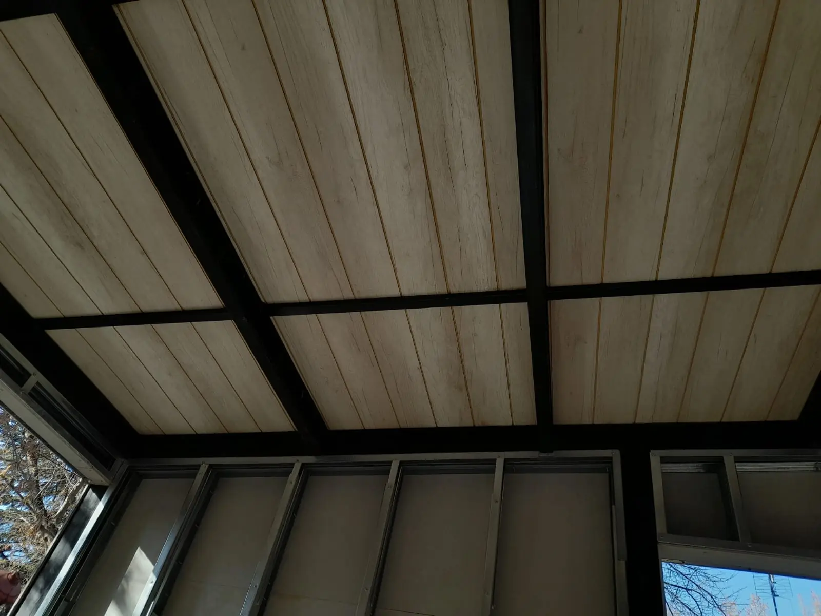 Vista del cielorraso de la galería con perfiles negros y carpinterías vidriadas