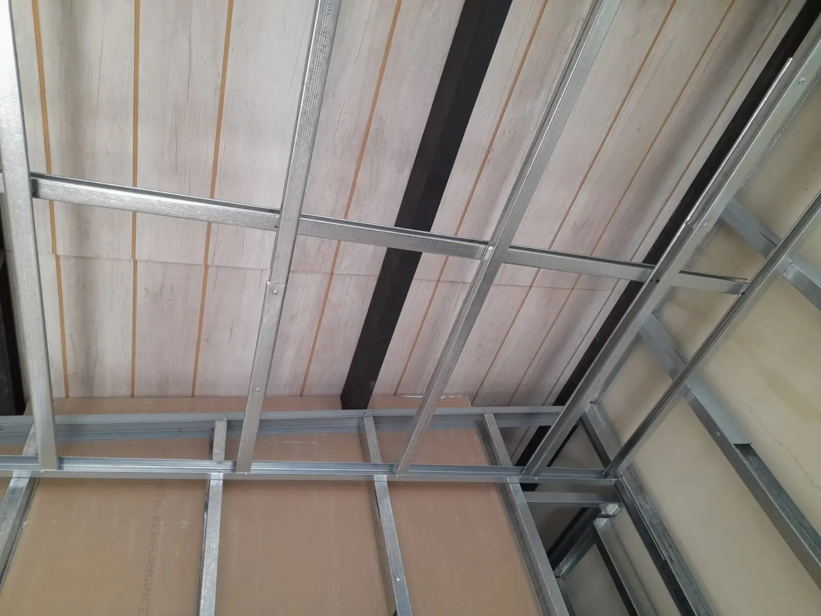 Cielorraso de tablas con estructura metálica a la vista y perfiles de montaje