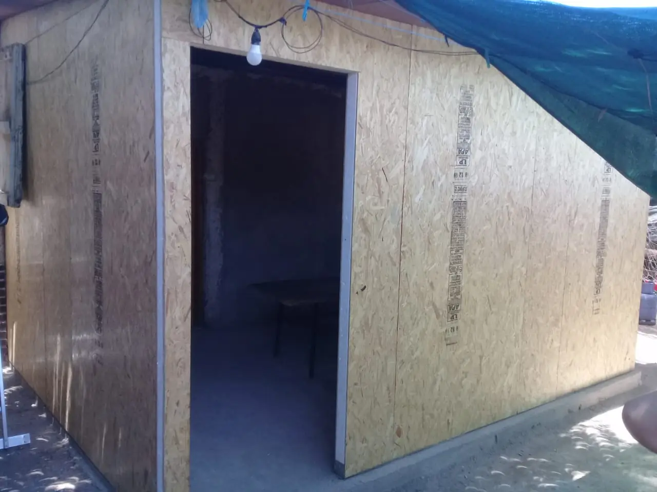 Puerta del módulo abierta mostrando el interior y el alero de chapa