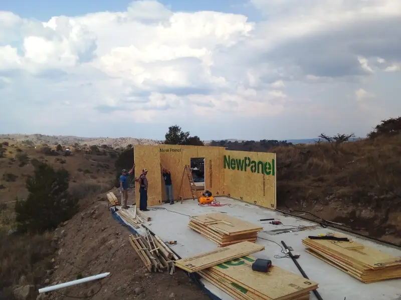 Primer muro de panel SIP montado sobre la platea con operarios trabajando
