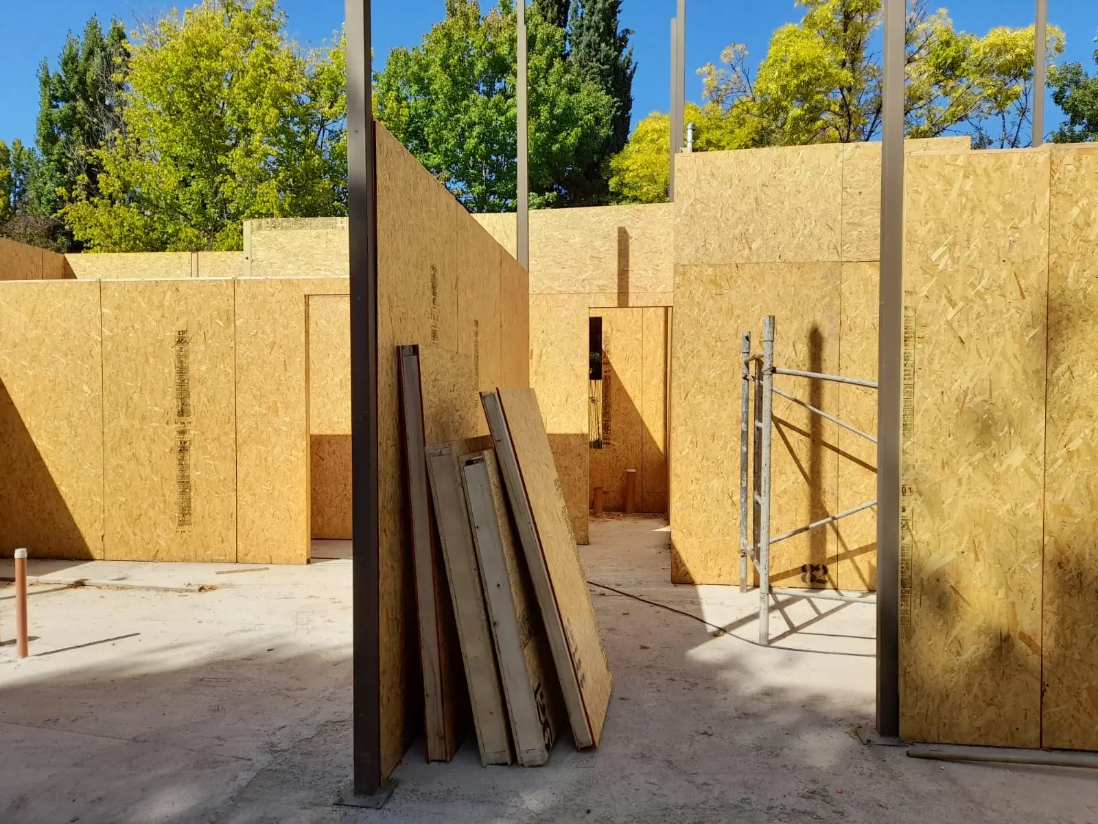 Esquina de muros con listones de madera apoyados y andamio de montaje