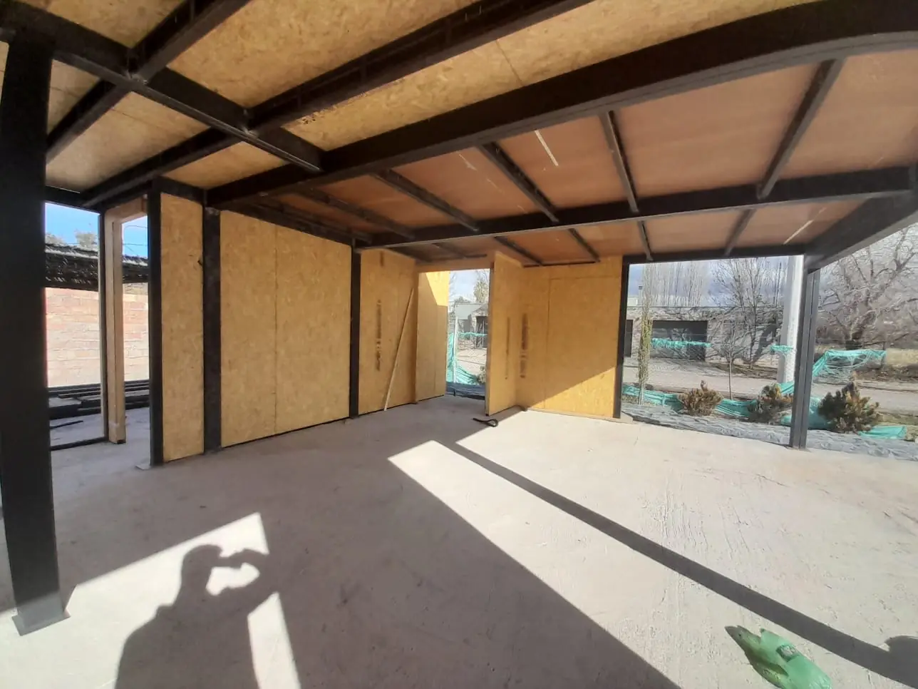 Interior bajo la estructura metálica, con vanos abiertos hacia el exterior