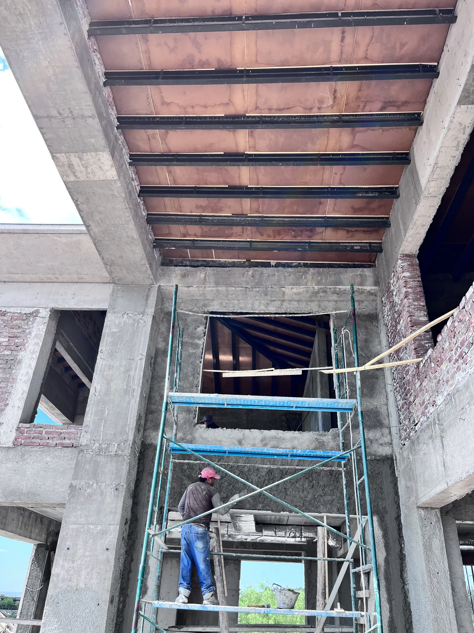 Doble altura con techo aislado sobre estructura metálica y andamio de obra