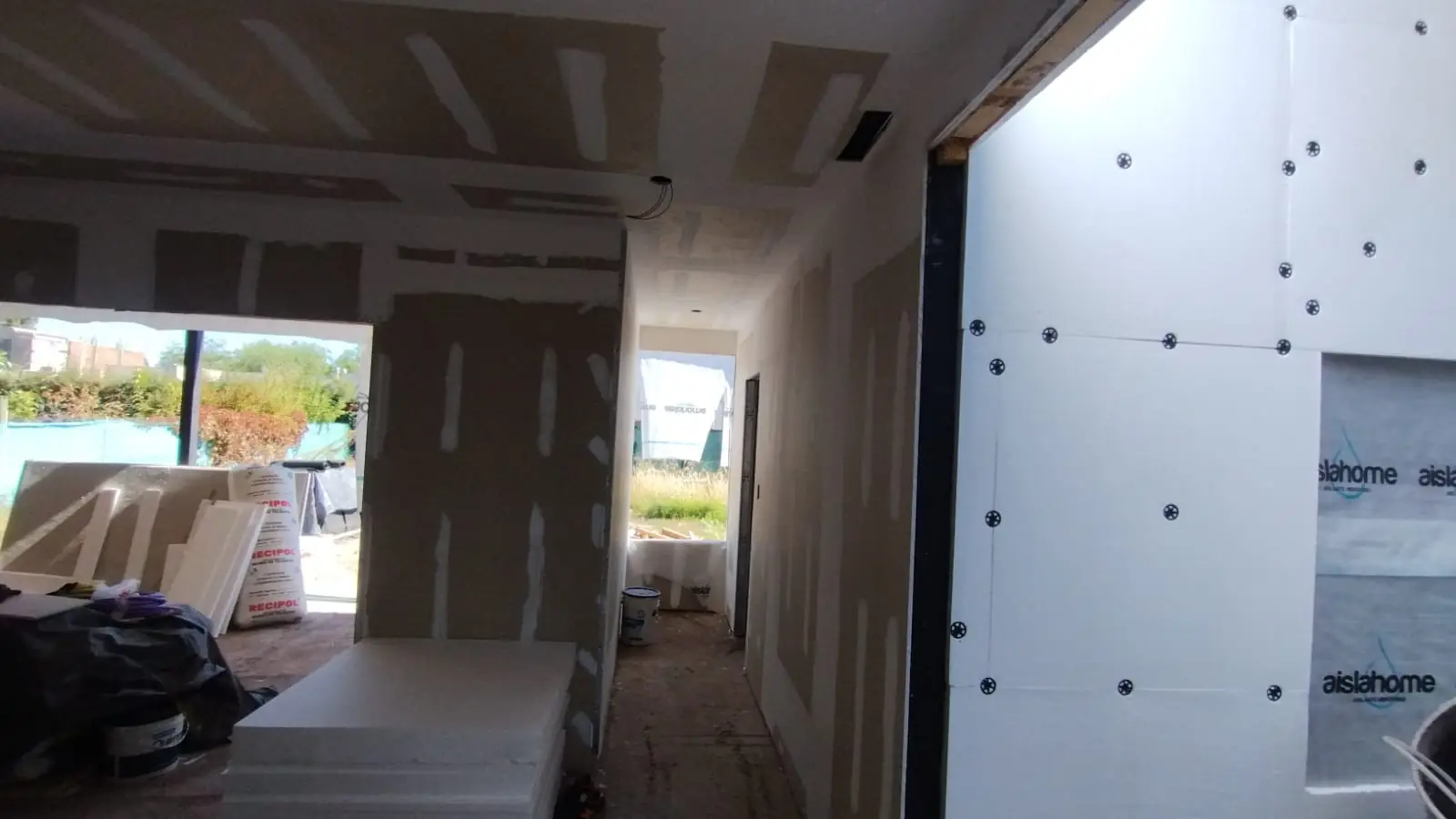 Interior en terminación con paso hacia el estar y placas EIFS visibles