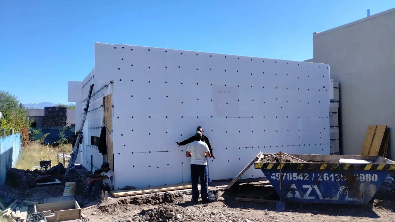 Operario colocando placas de EPS del sistema EIFS sobre el muro