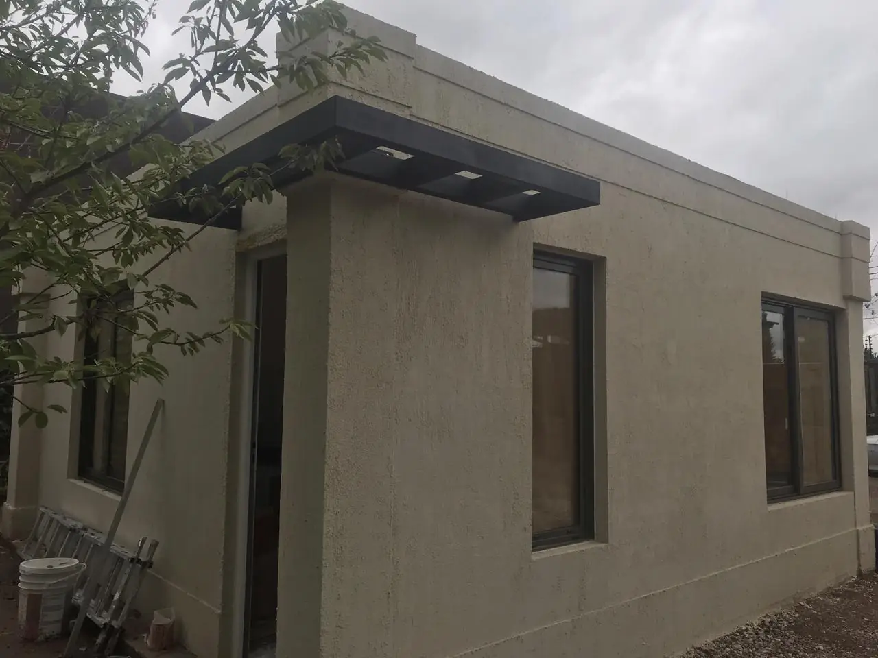 Lateral de la vivienda con alero metálico y aberturas ya colocadas