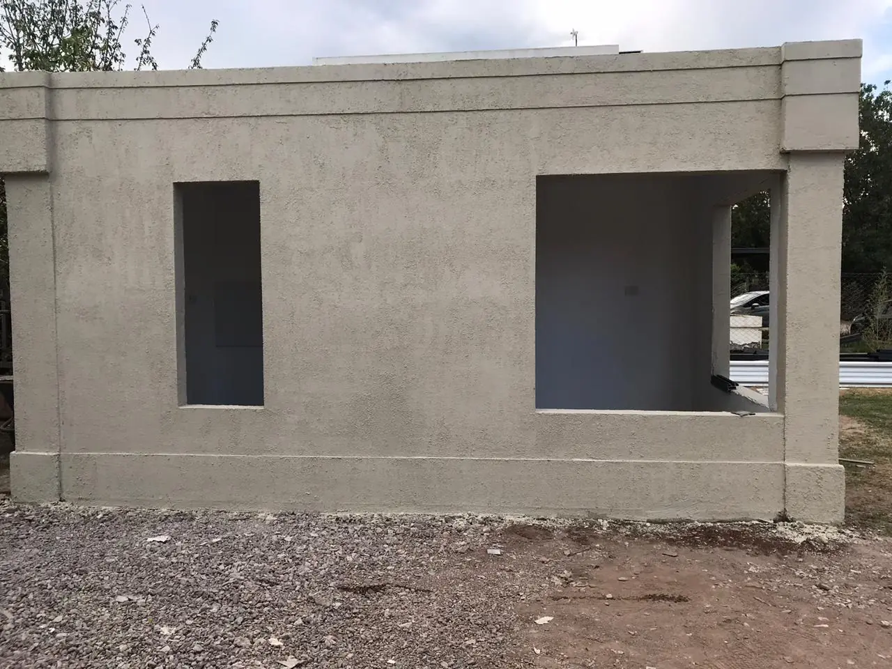 Vivienda revocada en obra con los vanos de ventana todavía abiertos