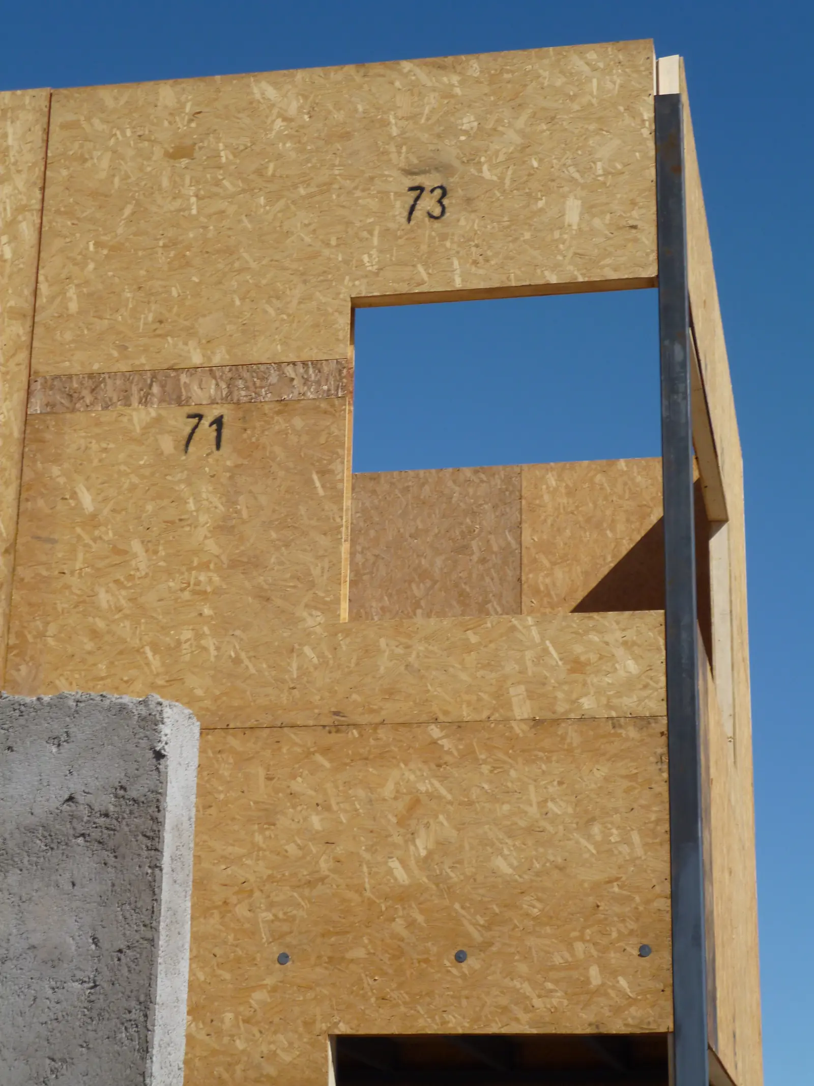 Muro de panel SIP con placa OSB y aberturas numeradas durante el montaje