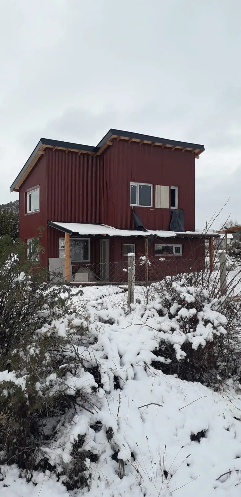La casa entre arbustos nevados en un día de invierno patagónico