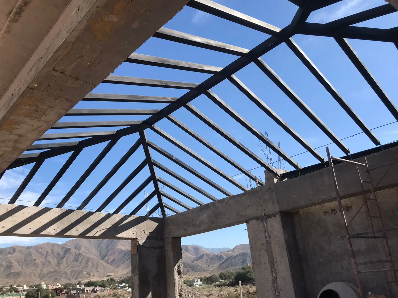 Estructura de cabios metálicos del techo abierta en abanico contra el cielo