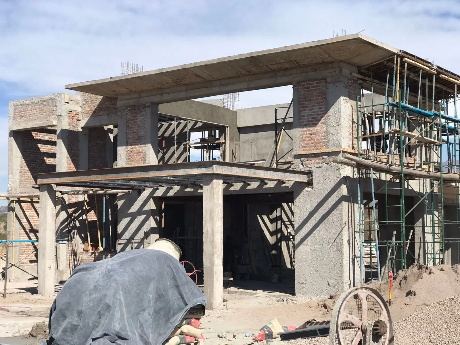Frente de la vivienda en obra con andamios y encofrados montados
