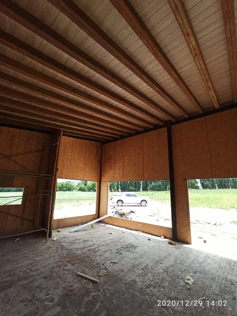 Interior con cielorraso de machimbre y gran vano abierto hacia el campo