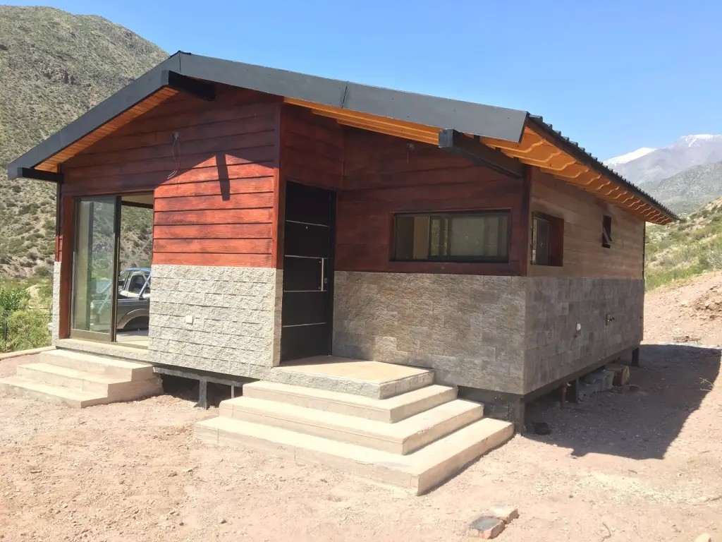 Vivienda elevada con escalera de hormigón y vista abierta al valle
