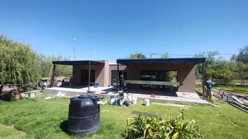 Vista general de la vivienda ya revocada con galería metálica sobre el parque
