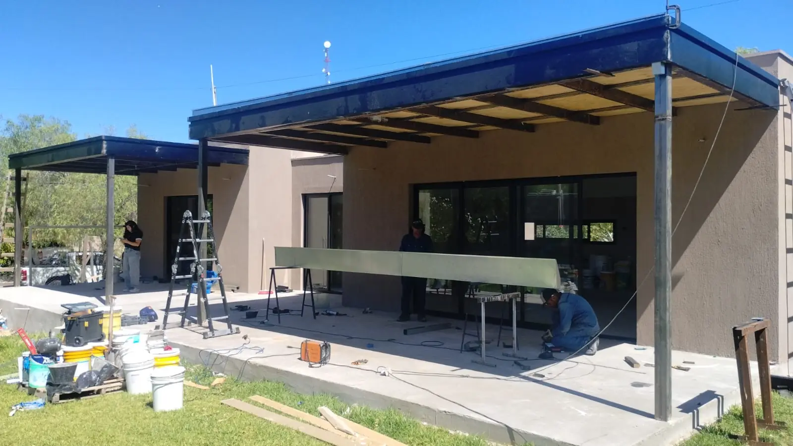 Alero metálico de la galería en montaje sobre la fachada terminada