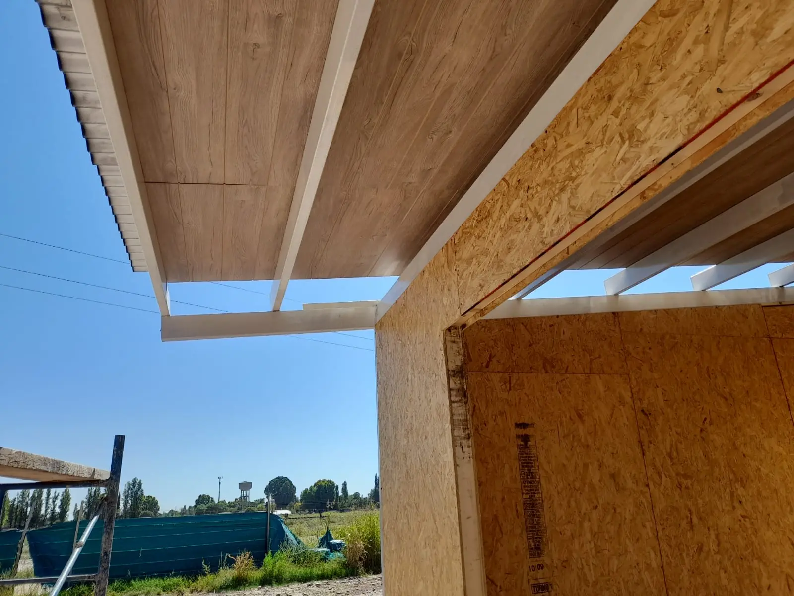 Interior con vigas de techo a la vista y abertura hacia el jardín
