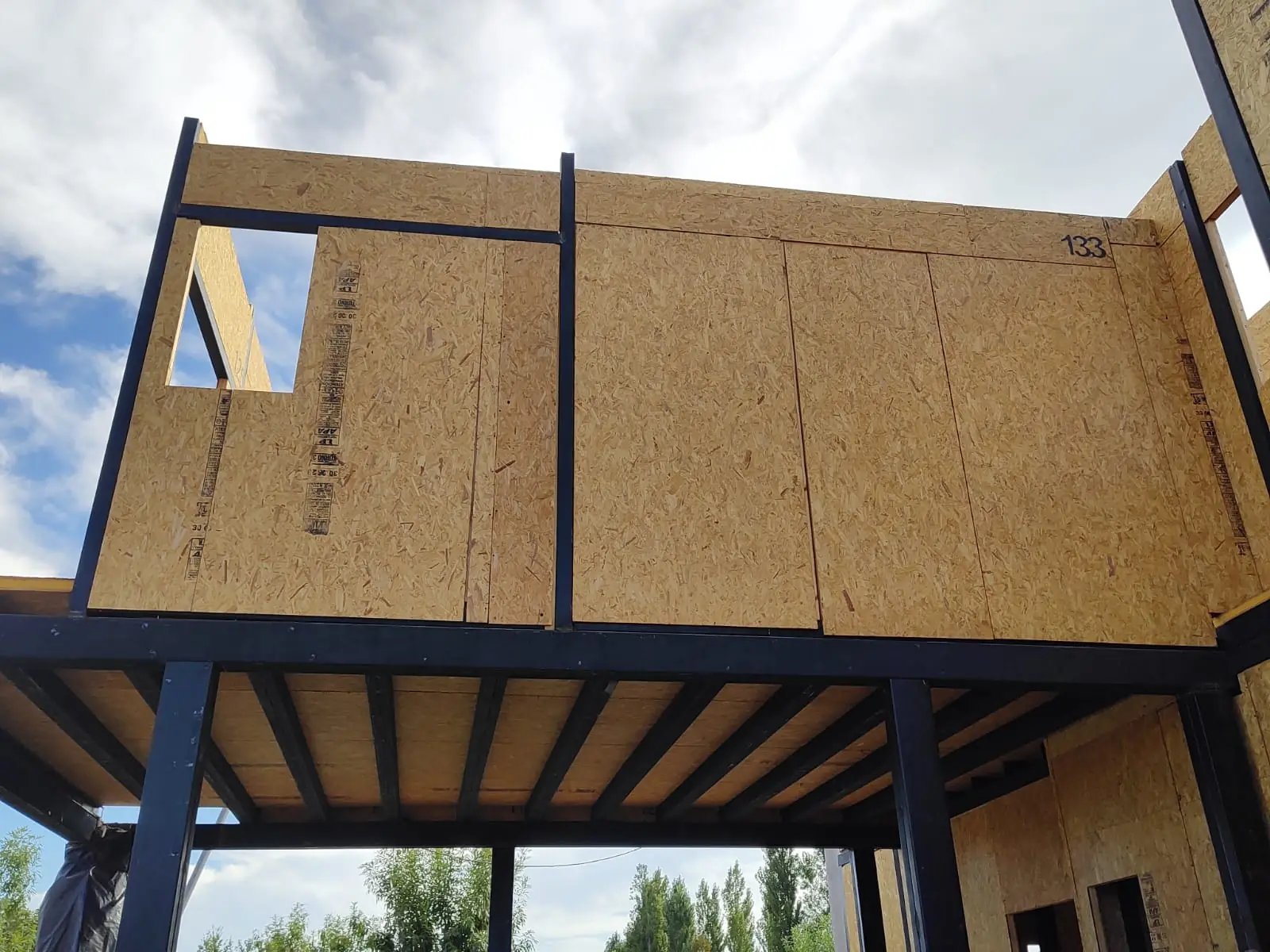 Planta alta con muros de panel SIP sobre estructura metálica, vista contrapicada