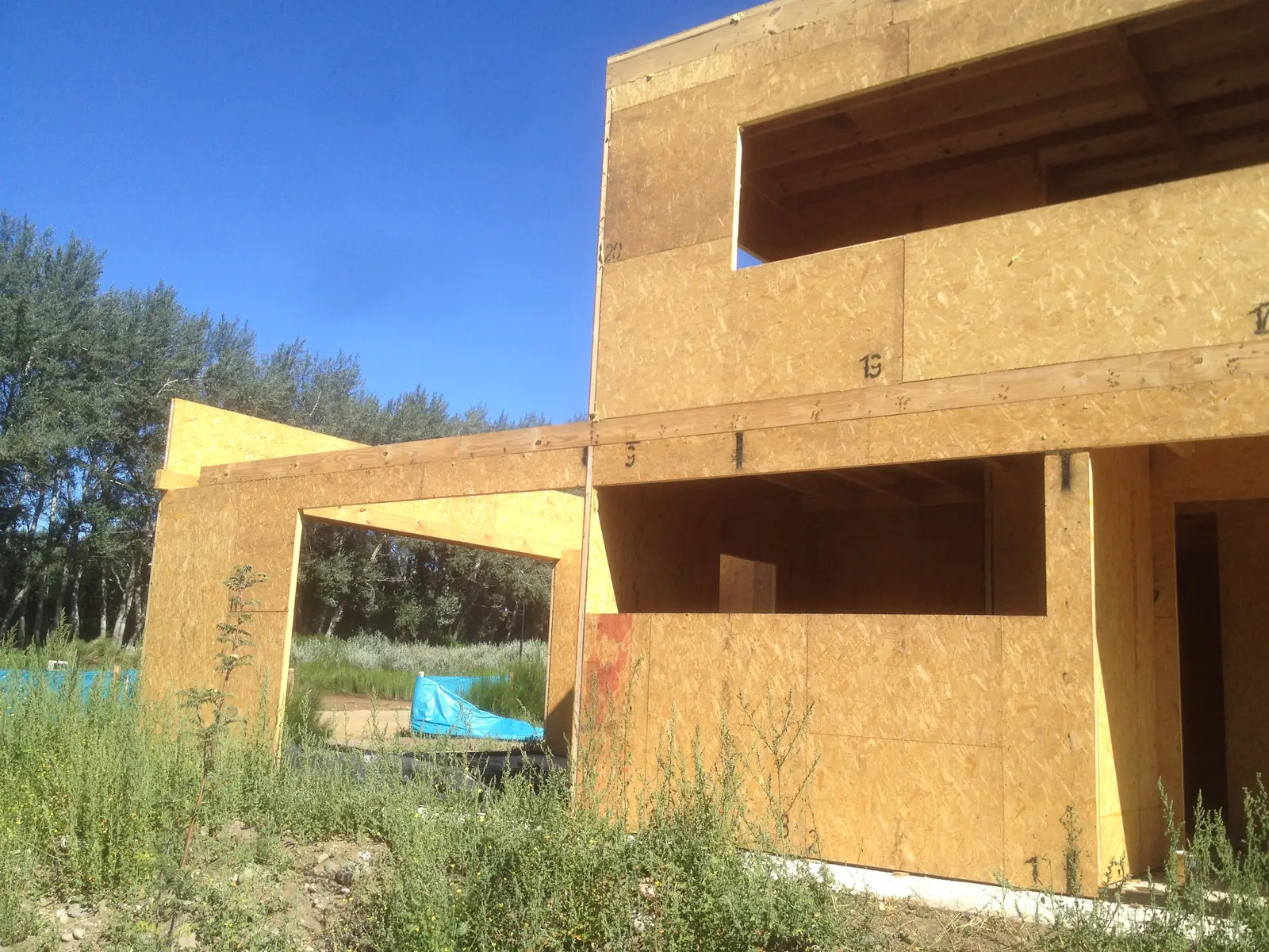 Vista general de la vivienda de panel SIP montada entre pastizales, bajo cielo despejado