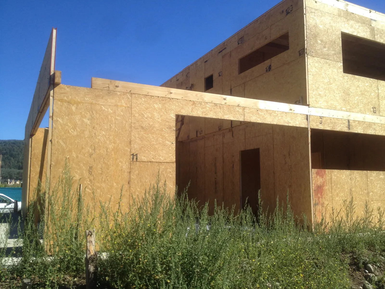Lateral de la casa con ventanas alargadas recortadas en los paneles SIP