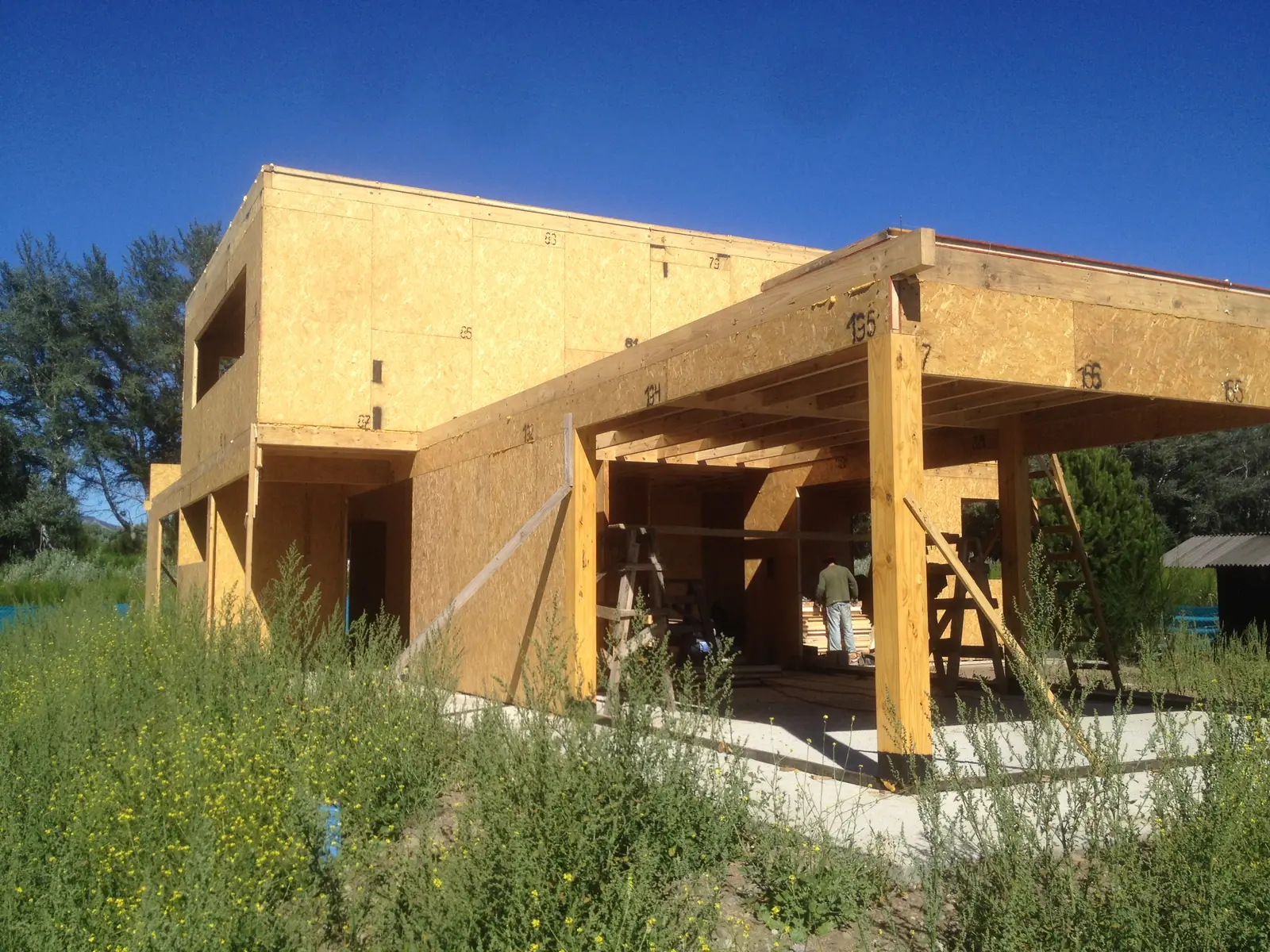 Galería exterior con columnas de madera bajo el voladizo del volumen superior