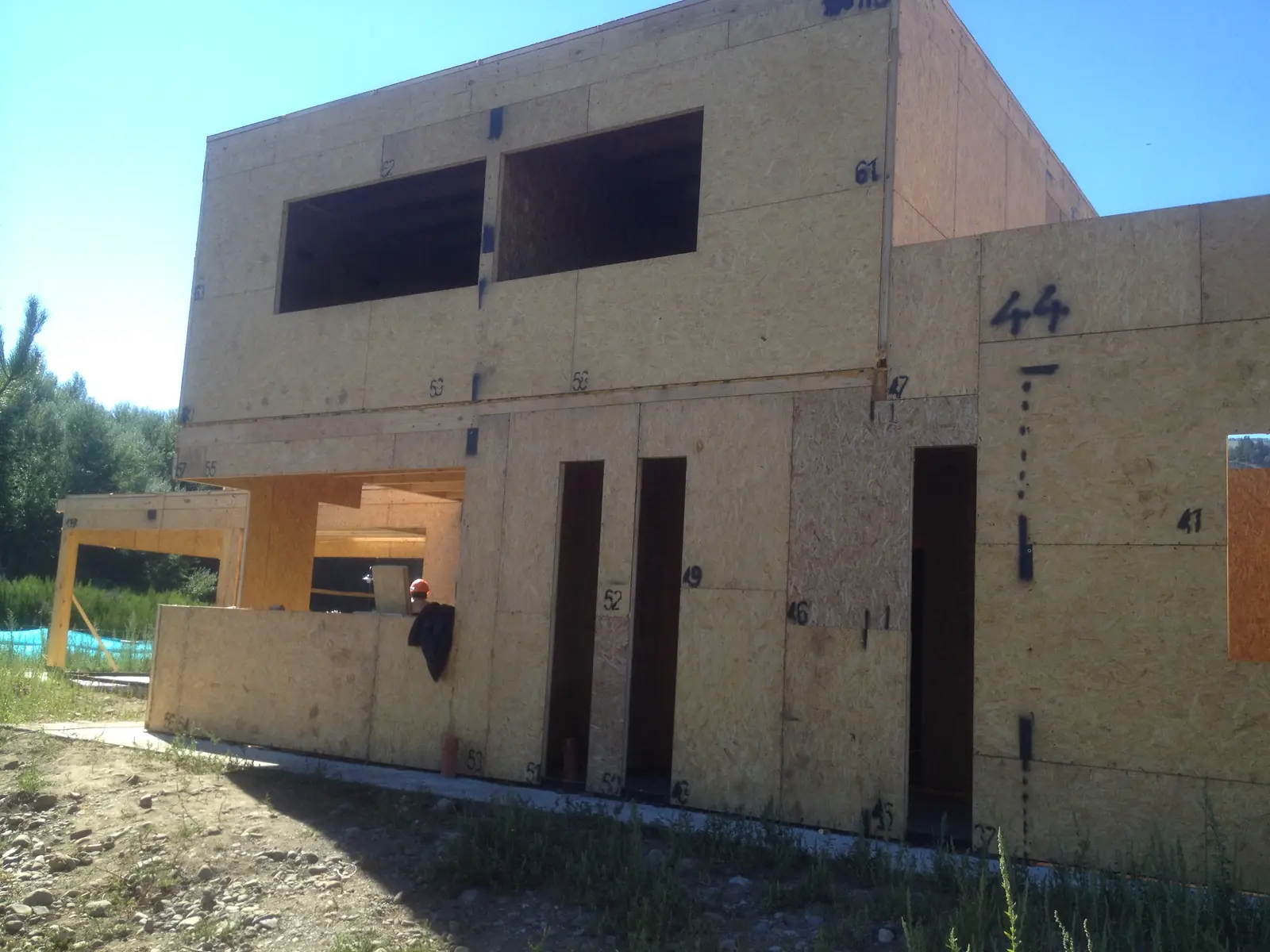 Fachada de la vivienda con muros de panel SIP y los vanos de ventanas ya recortados