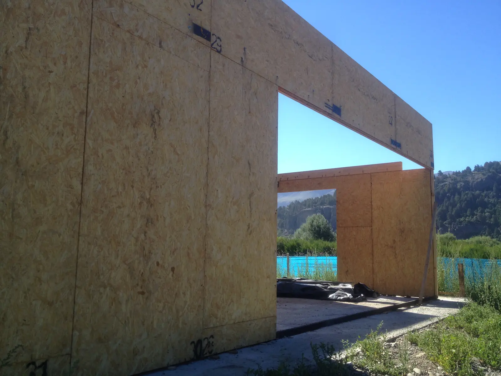 Muro de panel SIP con un gran vano rectangular abierto hacia el paisaje